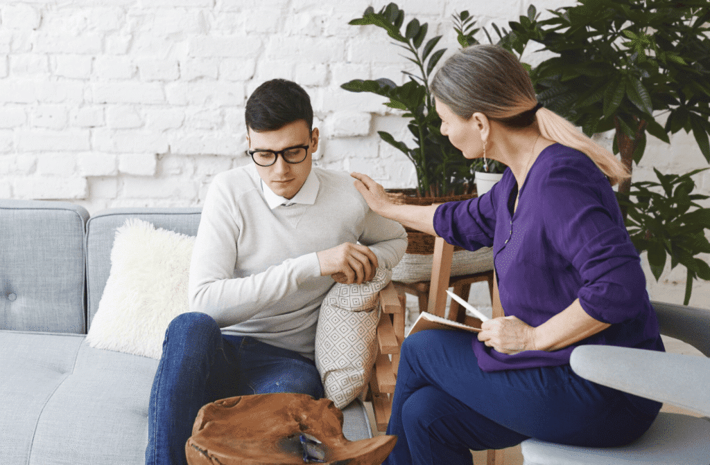 Therapist comforting an adult client on a couch during an individual therapy session in Paramus, New Jersey